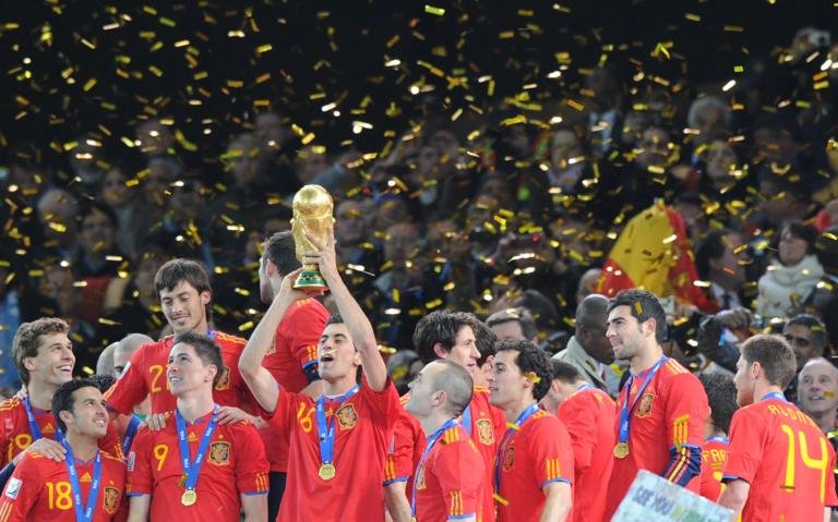 Spain's midfielder Sergio Busquets raises the trophy after the award ceremony following the 2010 FIFA football World Cup between the Netherlands and Spain on July 11, 2010 at Soccer City stadium in Soweto, suburban Johannesburg. Spain won 1-0. NO PUSH TO MOBILE / MOBILE USE SOLELY WITHIN EDITORIAL ARTICLE AFP PHOTO / PEDRO UGARTE (Photo credit should read PEDRO UGARTE/AFP via Getty Images)
